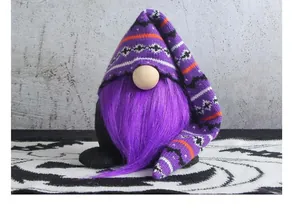Detailed shot of a purple knitted Halloween gnome plush with long striped hat