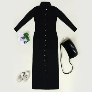 Flat lay view of a black long-sleeved button-down maxi dress with accessories