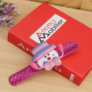 Close-up of a pink sequined Christmas slap bracelet with a cute plush snowman character.
