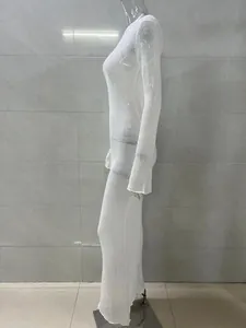 Detailed side view of a white semi-transparent long sleeve knit maxi dress on mannequin