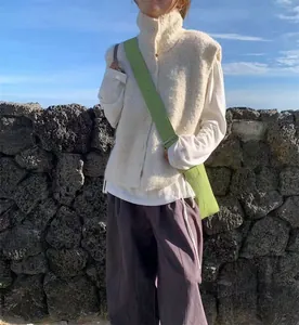 Gros plan d'une femme portant un gilet en maille bouclée à col montant