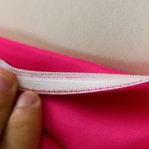 Dettaglio macro ravvicinato dell'elastico bianco e della cucitura su questo top a fascia rosa