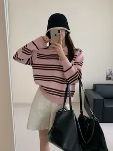 Pull polo à rayures roses et marron présenté dans un selfie décontracté au miroir.