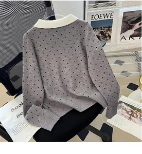 Close-up of a grey polka-dot knit cardigan with a classic white contrast lapel collar