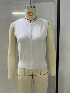 Detailed front view of a white knitted sleeveless button-up vest on a mannequin