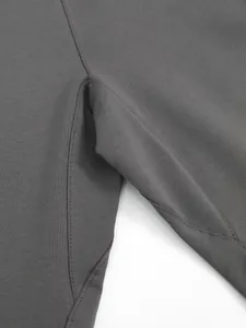 Gros plan sur la couture renforcée de l'entrejambe d'un pantalon de sport gris