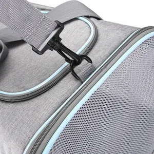 Detalle de la hebilla metálica y malla transpirable en un bolso gris para mascotas