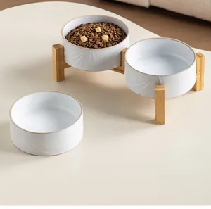 Vista detallada de cuencos de cerámica blanca para mascotas con soporte de madera de bambú.