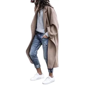Full view of oversized camel wool coat with distressed jeans and casual white sneakers