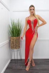Elegant red evening gown with sheer mesh panels and sparkling rhinestones throughout