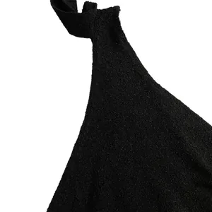 Close-up of black textured fabric and shoulder strap of a slim-fit maxi dress