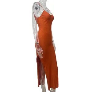 Side profile of orange knit cami dress with high side slit on transparent mannequin