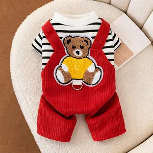 Detailed view of red corduroy pet overalls with a bear patch over a striped shirt