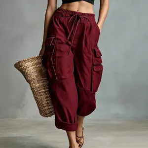 Detail view of maroon high-waist cargo pants with multiple pockets and drawstring