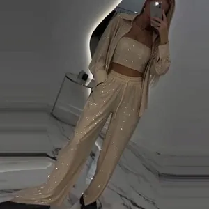 Detailed view of women's sparkly three-piece set with long-sleeve shirt and wide pants