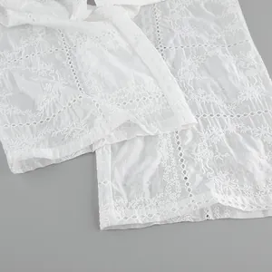 Gros plan sur la délicate broderie anglaise florale d'un ensemble d'été blanc
