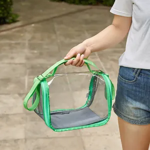 Portable transparent green bird carrier bag being held outdoors for small pet parrots