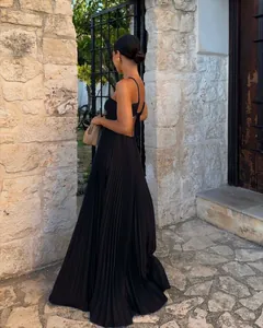 Rear view detail of elegant black pleated maxi dress with thin straps and open back design