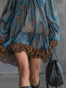 Close-up of elegant blue leopard print mini dress showing layered ruffled hemline texture