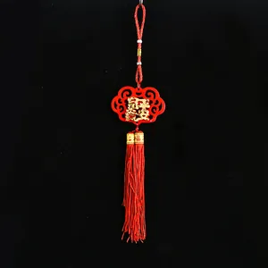 Traditional Chinese New Year hanging ornament with red tassel and golden Fu character.