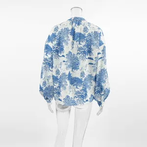 Back view of a blue and white printed shirt with lantern sleeves and mandarin collar.