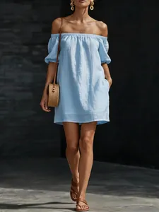 Close-up detail of a light blue off-the-shoulder summer dress in cotton linen fabric