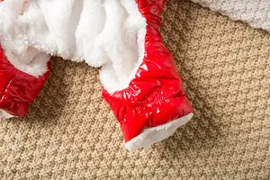 Dettaglio della giacca invernale rossa lucida per cani con calda fodera in pile bianca.