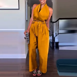 Detailansicht eines stylischen senfgelben Neckholder-Tops und einer weiten Hose.