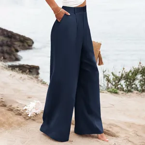 Dettaglio di pantaloni casual blu scuro a vita alta da donna sulla spiaggia estiva