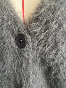 Close-up of black button and grey mink wool texture on a v-neck cardigan