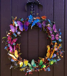 Corona de primavera artesanal con mariposas de colores y luces LED en puerta de madera