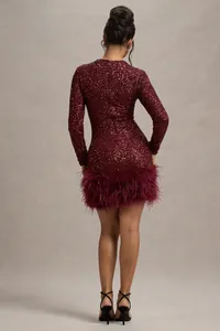 Rückansicht eines bordeauxroten Paillettenkleides mit luxuriösem Federbesatz am Saum.