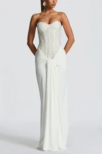 Detailed view of white strapless corset dress with sequins and elegant draped skirt