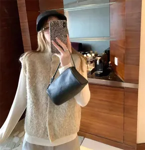 Détail d'un gilet à col roulé en maille bouclée crème porté par un mannequin