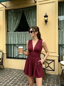 Eleganter weinroter Jumpsuit mit tiefem V-Ausschnitt in einem Streetstyle-Setting.