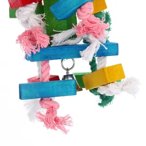 Détail des blocs de bois colorés et des nœuds de corde en coton d'un jouet pour perroquet.