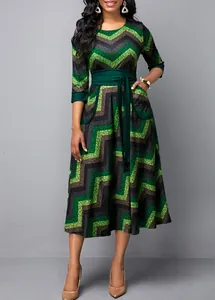 Detailed view of women's round neck dress with green zigzag print and high waist belt