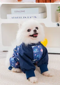Detail view of a white Pomeranian wearing a navy waterproof space-patterned pet bodysuit.