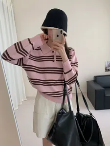 Selfie miroir montrant les détails du pull polo en maille à rayures roses.