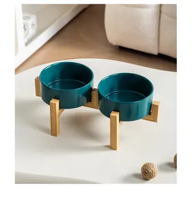 Vista dettagliata delle doppie ciotole in ceramica verde scuro su supporto in legno