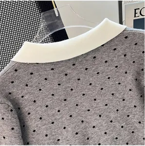 Close-up of grey polka dot knit cardigan featuring a contrast white lapel collar.