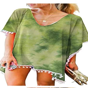 Λεπτομέρεια πράσινου tie-dye φορέματος παραλίας με λευκά φουντάκια.