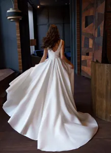 Detailed back view of an elegant white backless evening gown featuring a flowing satin skirt