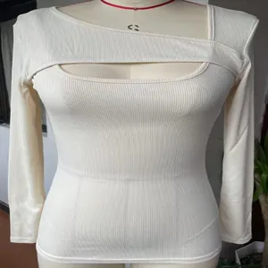 Dettaglio con la scollatura irregolare cut-out e la trama a coste del top aderente