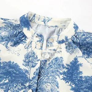 Close-up detail of women's stand collar shirt with blue forest toile de jouy print.