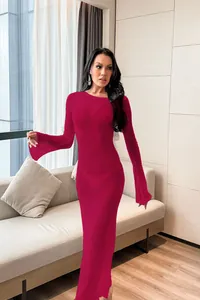 Full body view of a long-sleeved maroon cover-up maxi dress in a modern living room