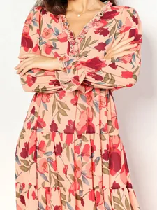 Close-up detail of a feminine long-sleeved floral maxi dress featuring elegant ruffle V-neck