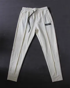 Flat lay of cream men's athletic sweatpants with elastic waist and black drawstring