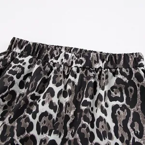 Detailed macro view showing the elastic waistband of leopard print wide-leg trousers.