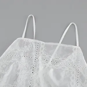 Vue détaillée macro d'un caraco blanc brodé avec des motifs de dentelle ajourés complexes